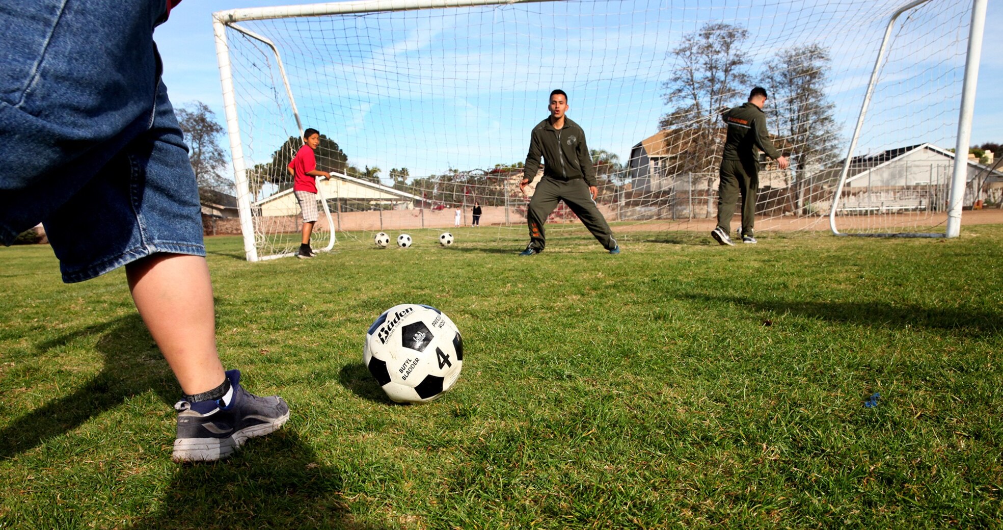 Marines with Combat Logistics Regiment 1, 1st Marine Logistics Group, play goalie during a morning workout at Jefferson Elementary School, Feb. 13, 2014. Marines with CLR-1 and 1st Medical Battalion, volunteered their time to support more than 500 students in their new fitness program known as “Motion.” During their visit Marines led various events, such as push-ups, squats, soccer and basketball.