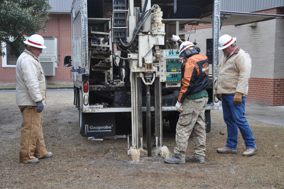 From left to right: Danny Hewett and John Howley (both drill rig operators) and Joel Trainor, geologist, use a drill rig to extract a soil sample at Jenkins High School as part of a National Engineers Week outreach event, Feb. 13, 2014. 
