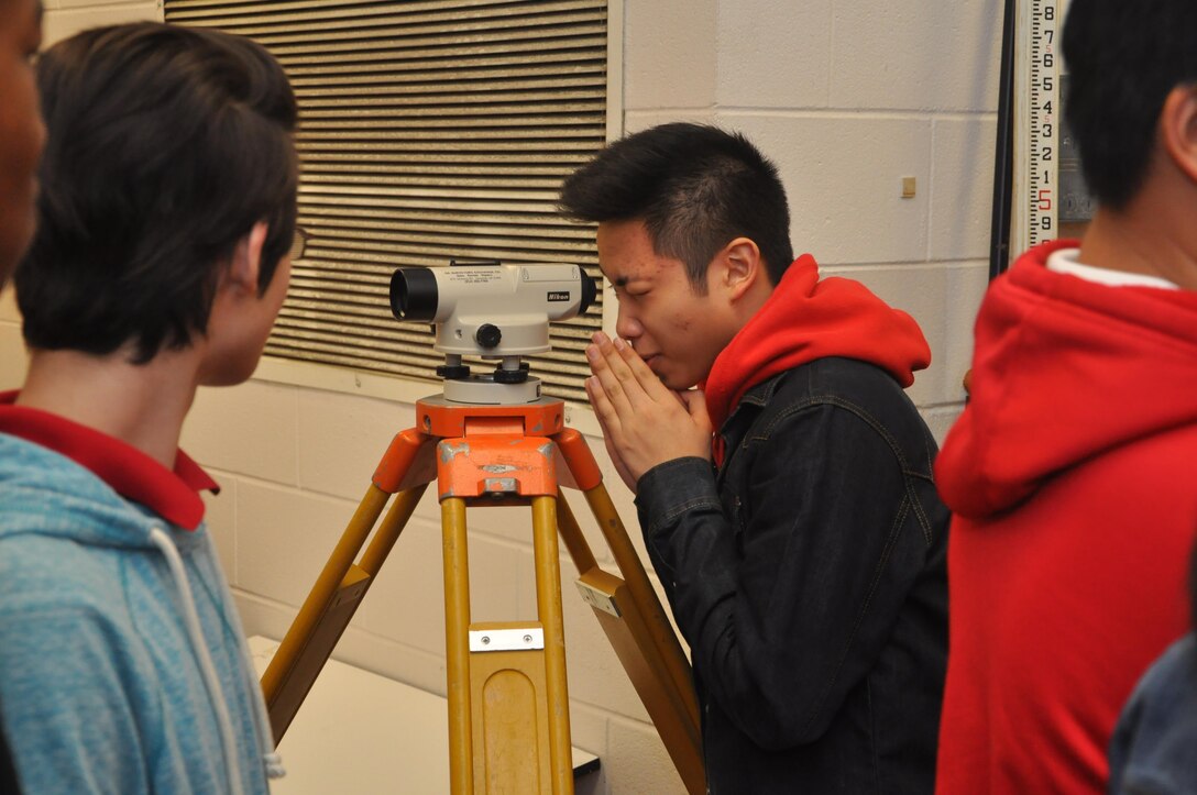 Jenkins High School students look through a surveying scope during a visit by the U.S. Army Corps of Engineers, Feb. 13, 2014. The visit aimed to recruit students to pursue science and engineering related career paths as part of National Engineers Week.