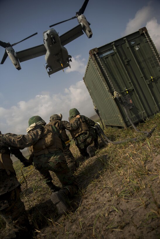 Royal Thai and U.S. Marines brace for high winds created by an MV-22B Osprey at Utaphao, Kingdom of Thailand Feb. 17 during Exercise Cobra Gold 2014. Cobra Gold, in its 33rd iteration, demonstrates the U.S. and the Kingdom of Thailand’s commitment to our long-standing alliance and regional partnership, prosperity and security in the Asia-Pacific region. The U.S. Marines are Landing Support Specialists with Combat Logistics Battalion 4, Combat Logistics Regiment 3, 3rd Marine Logistics Group. The Royal Thai Marines are shore management with Landing Force Company, Support Regiment, Marine Corps Division.