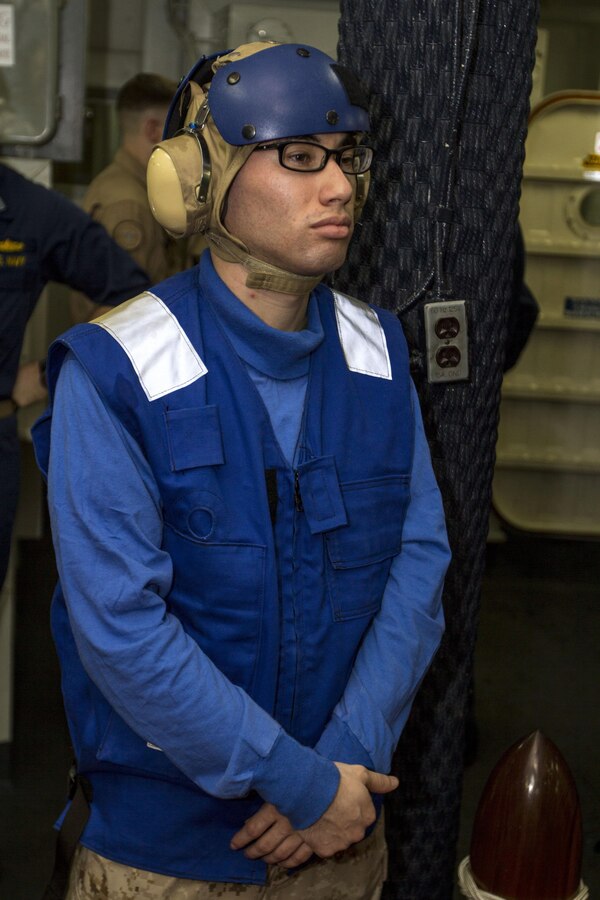U.S. Marine Corps Cpl. Roberto A. Salcedo, an administrative specialist with the 26th Marine Expeditionary Unit and a Los Angeles native, stands as a sideboy during a tending the side ceremony Sep. 30, 2013 aboard the USS Kearsarge while at sea. Tending the side is a naval and Marine Corps tradition executed to welcome distinguished visitors aboard a ship. (U.S. Marine Corps photo by Cpl. Kyle N. Runnels/released)
