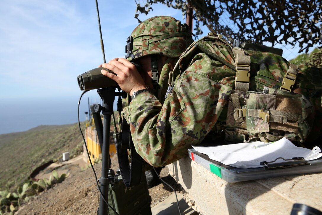 A soldier with the Japan Ground Self-Defense Force looks at his targets while training with U.S. Marines from 1st Air Naval Gunfire Liaison Company during Exercise Iron Fist 2014 aboard San Clemente Island, Calif., Feb. 13, 2014. Iron Fist 2014 is an amphibious exercise that brings together Marines and sailors from the 15th Marine Expeditionary Unit, other I Marine Expeditionary Force units, and soldiers from the JGSDF, to promote military interoperability and hone individual and small-unit skills through challenging, complex and realistic training. (U.S. Marine Corps photo by Lance Cpl. Anna K. Albrecht/Released)