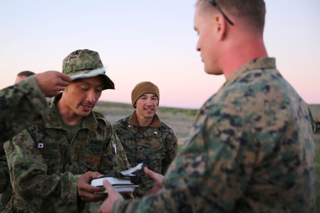 A soldier with the Japan Ground Self-Defense Force shares a Japanese Meal-Ready-to-Eat with a U.S. Marine from 1st Air Naval Gunfire Liaison Company during Exercise Iron Fist 2014 aboard San Clemente Island, Calif., Feb. 14, 2014. Iron Fist 2014 is an amphibious exercise that brings together Marines and sailors from the 15th Marine Expeditionary Unit, other I Marine Expeditionary Force units, and soldiers from the JGSDF, to promote military interoperability and hone individual and small-unit skills through challenging, complex and realistic training. (U.S. Marine Corps photo by Lance Cpl. Anna K. Albrecht/Released)