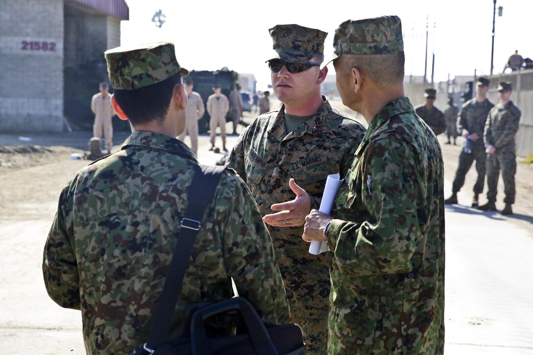 U.S. Marine Chief Warrant Officer 3 Ronald Molamphy, middle, battalion maintenance officer, 3rd Assault Amphibian Battalion, speaks with officials of the Japan Ground Self-Defense Force about the AAV-7 Assault Amphibious Vehicles during Exercise Iron Fist 2014 aboard Camp Pendleton, Calif., Feb. 16, 2014. Iron Fist is an amphibious exercise that brings together Marines and sailors from the 15th Marine Expeditionary Unit, other I Marine Expeditionary Force units, and soldiers from the JGSDF, to promote military interoperability and hone individual and small-unit skills through challenging, complex and realistic training

