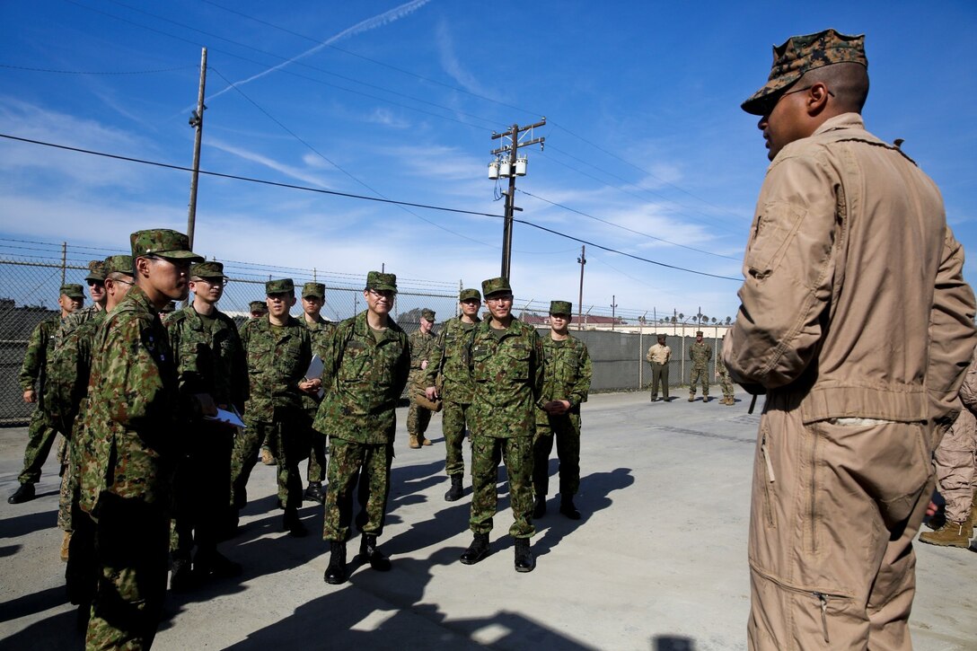 U.S. Marine Staff Sgt. Pedro Guerrero, right, section leader, 3rd Assault Amphibian Battalion, briefs officials of the Japan Ground Self-Defense Force on safety procedures while conducting a splash demonstration whit AAV-7 Assault Amphibious Vehicles during Exercise Iron Fist 2014 aboard Camp Pendleton, Calif., Feb. 16, 2014. Iron Fist is an amphibious exercise that brings together Marines and sailors from the 15th Marine Expeditionary Unit, other I Marine Expeditionary Force units, and soldiers from the JGSDF, to promote military interoperability and hone individual and small-unit skills through challenging, complex and realistic training. (U.S. Marine Corps photo by Lance Cpl. Ricardo Hurtado/Released)