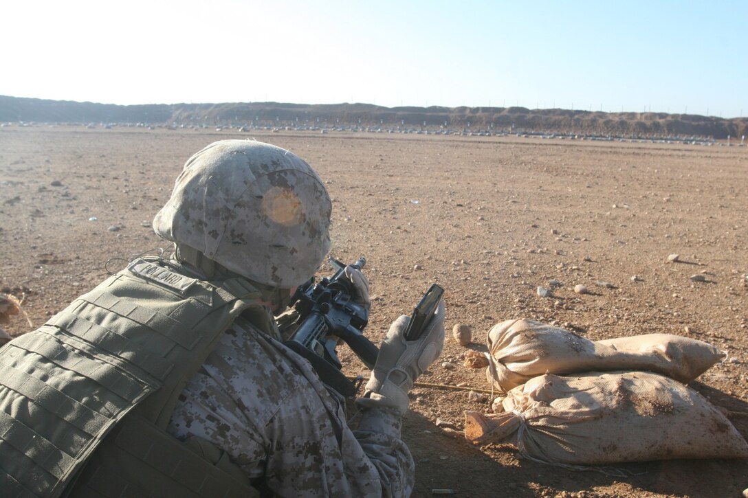 Lance Cpl. Shane Pollard, food service specialist, Marine Expeditionary Brigade - Afghanistan, waits to show a range coach his weapon and magazine are clear and empty of rounds during a live-fire range exercise aboard Camp Leatherneck, Helmand province, Afghanistan, Feb. 11, 2014. The exercise was used to prepare Marines to respond to a hostile threat aboard the base should one arise.