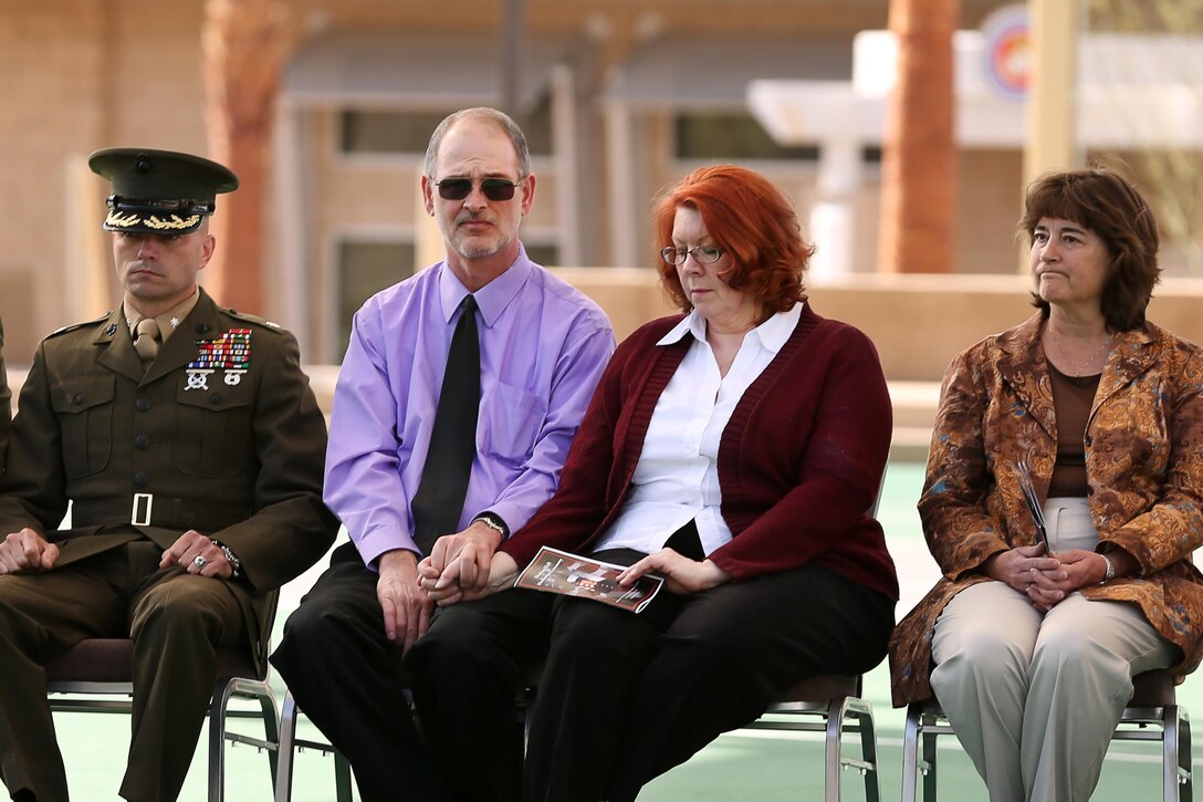 Parents of Cpl. Jason L. Dunham, Dan and Debra Dunham, sit hand-in-hand as their son’s award citation is read during the dedication ceremony of the Cpl. Jason L. Dunham Memorial Mess Hall, Feb. 18. Dunham, then serving with 3rd Battalion, 7th Marine Regiment, suffered fatal wounds after covering a grenade with his helmet and body to save the lives of his fellow Marines in Karabilah, Iraq, on April 14, 2004.