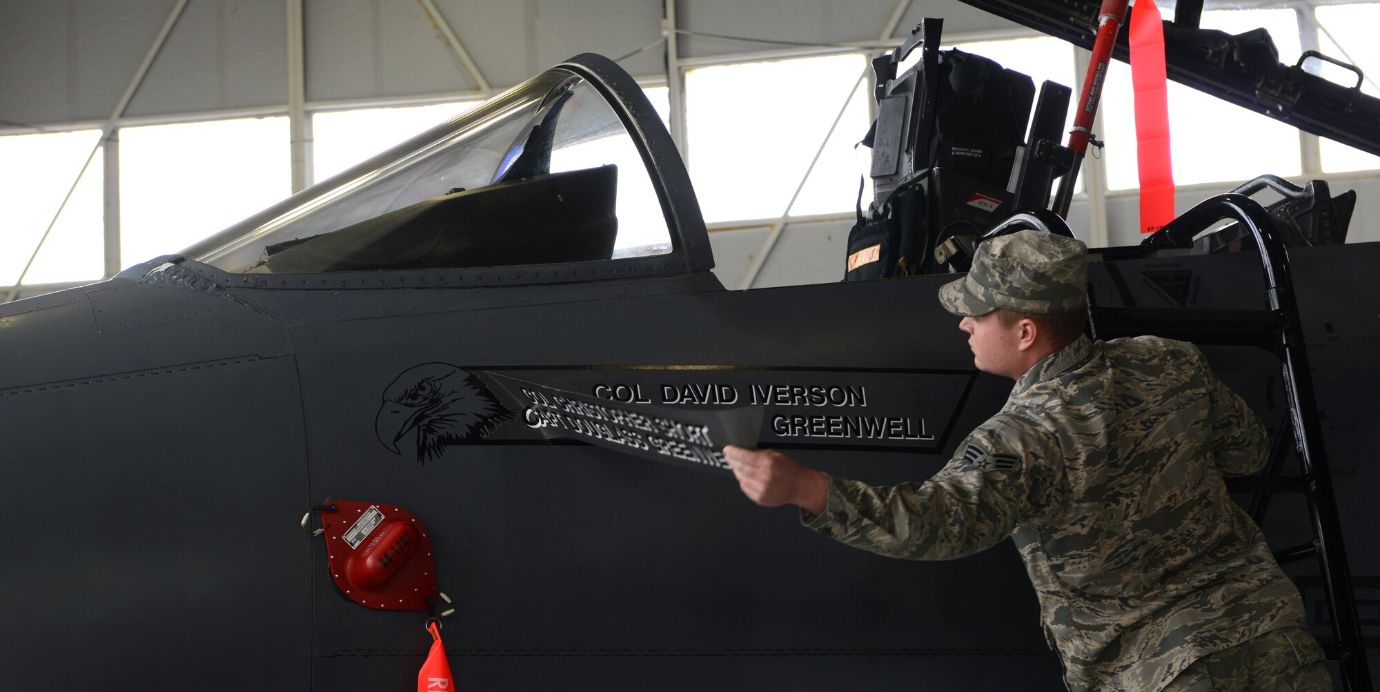 An Airman from the 366th Fighter Wing unveils Col. Dave Iverson’s name, off the flagship F-15E Strike Eagle Feb. 18, 2014, at Mountain Home Air Force Base, Idaho. Along with the passing of the guidon, the unveiling of the new commander’s name is a ceremonial gesture during the change-of-command ceremony. (U.S. Air Force photo by Airman 1st Class Malissa Lott/RELEASED)