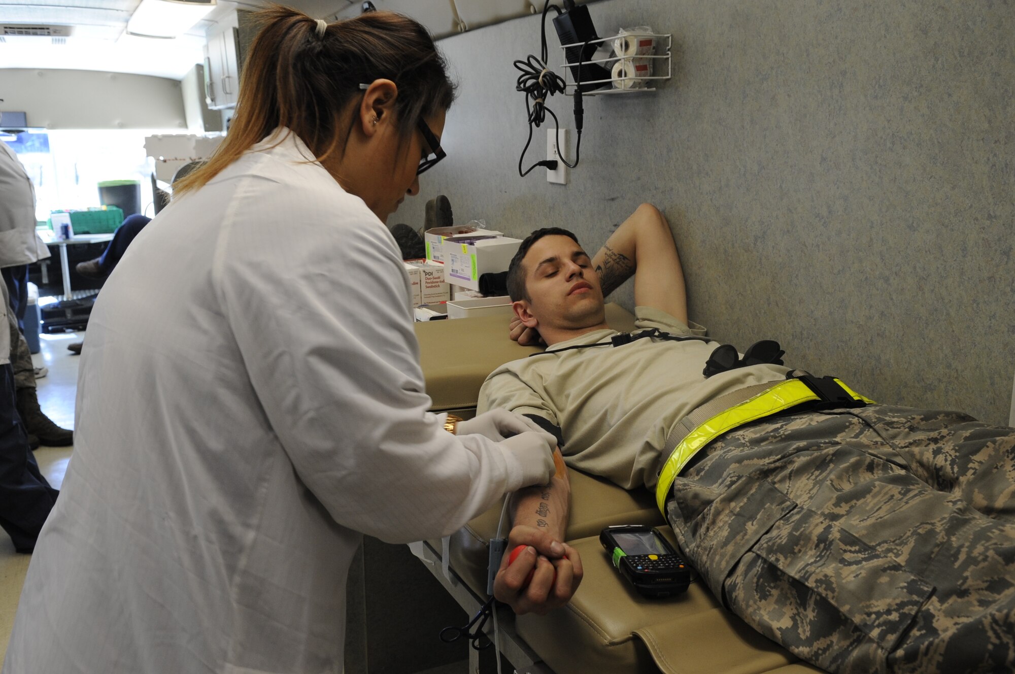 Leilani Samorano, American Red Cross phlebotomist, inserts a needle into U.S. Air Force Senior Airman Cody Cook, 354th Aircraft Maintenance Unit crew chief, during a blood drive at Davis-Monthan Air Force Base, Ariz., Feb. 14, 2014. D-M hosts the American Red Cross for blood donations every month, alternation between the 355th Fighter Wing and the Medical Group. This was the first time the 355th Maintenance Group hosted the American Red Cross, specifically for maintainers. (U.S. Air Force photo by Airman 1st Class Betty R. Chevalier/Released)