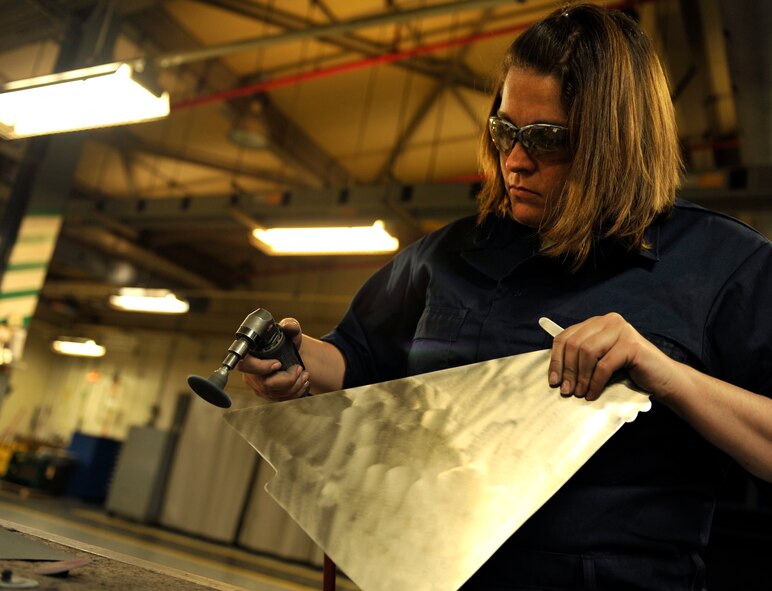 U.S. Air Force Staff Sgt. Tracy Powell, 18th Equipment Maintenance Squadron aircraft metals technology journeyman, polishes a metal part of an F-15 Eagle on Kadena Air Base, Japan, Feb. 14, 2014. 18th EMS operates 24/7 to provide metal work for all the aircraft assigned to Kadena. (U.S. Air Force photo by Naoto Anazawa)