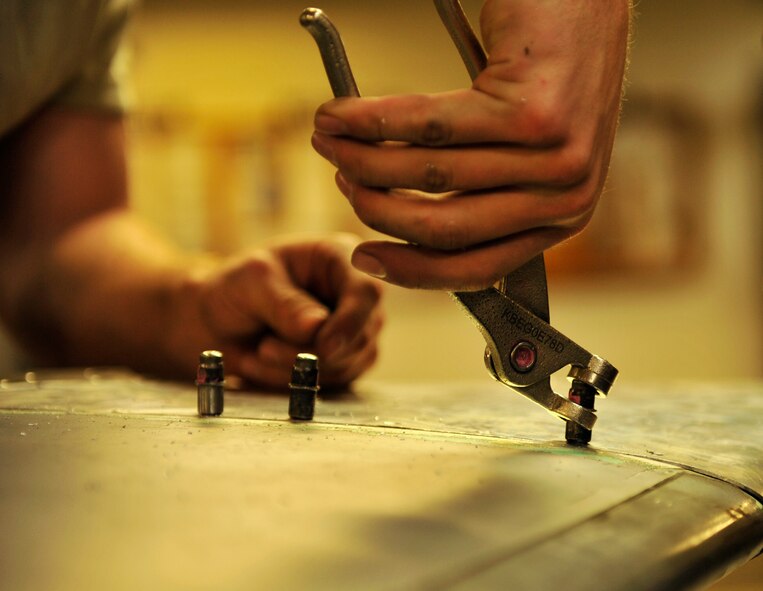 U.S. Air Force Airman Justin O'Neal, 18th Equipment Maintenance Squadron aircraft structural maintenance journeyman, screws into the vertical stabilizer of an F-15 Eagle on Kadena Air Base, Japan, Feb. 14, 2014. The 18 EMS directly supports sortie production for a 14,000-hour annual flying program. (U.S. Air Force photo by Naoto Anazawa)