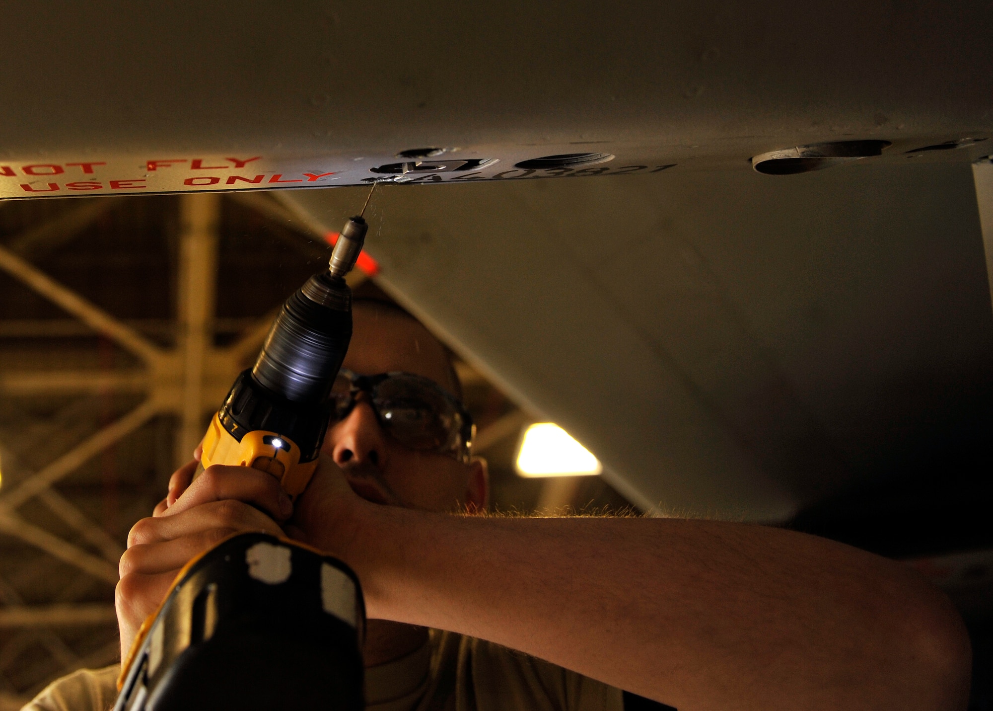 U.S. Air Force Senior Airman Patrick Lopez, 18th Equipment Maintenance Squadron aircraft metals technology journeyman, drills holes into an F-15 Eagle on Kadena Air Base, Japan, Feb. 14, 2014. The 18th EMS supports heavy maintenance for Kadena-assigned aircraft and provides limited maintenance for transient and associate unit aircraft. (U.S. Air Force photo by Naoto Anazawa)