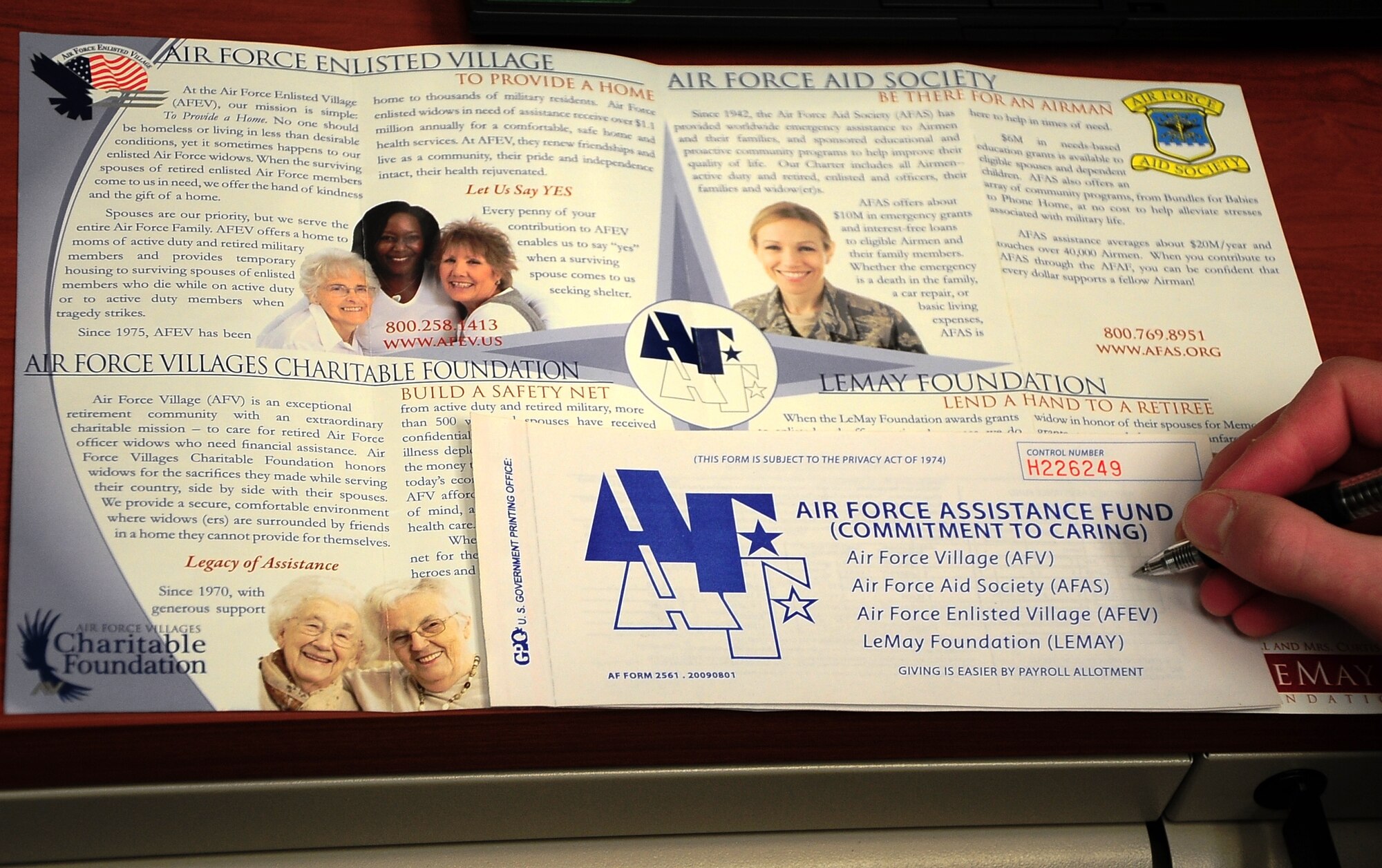 An Airman reads the brochure detailing the Air Force Assistance Fund’s various charities and prepares to fill out an official donation form. The AFAF is an annual effort to raise funds for the charitable affiliates that provide support to Air Force families in need. (U.S. Air Force Photo/Airman John Day)