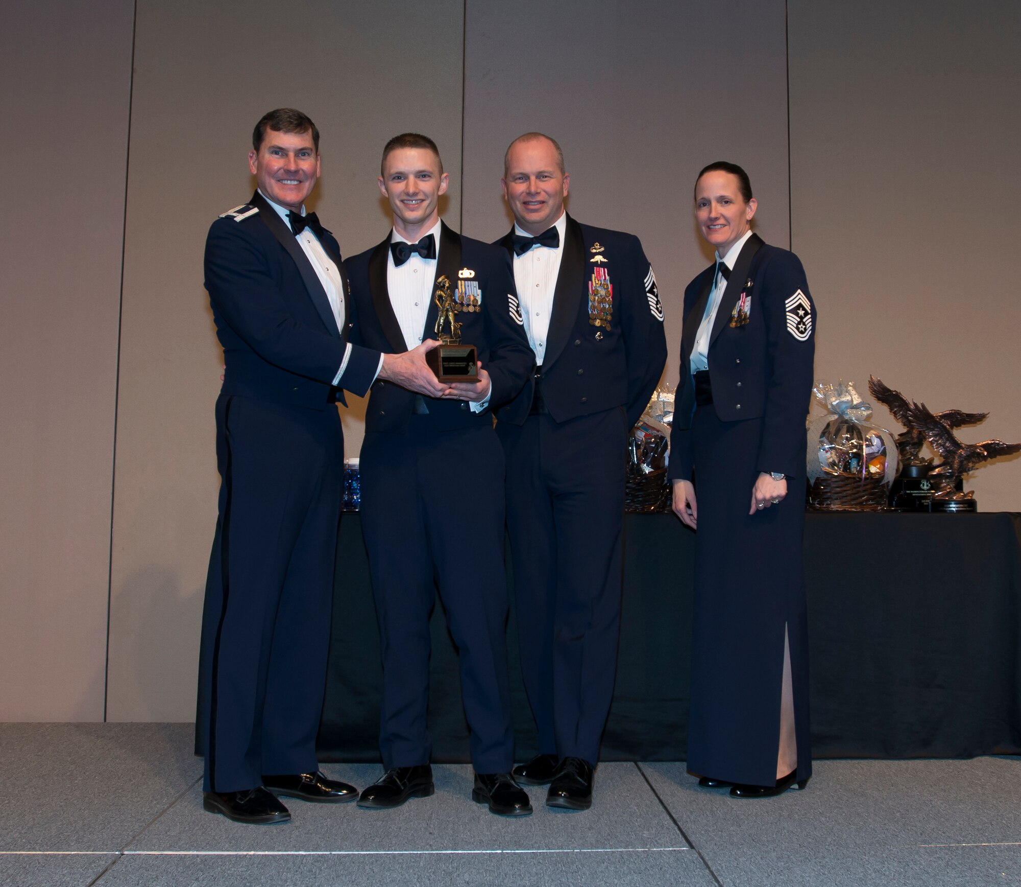 Col. John S. Tuohy, Washington Air National Guard Assistant Adjutant General, Chief Master Sgt. James W. Hotaling Air National Guard Command Chief and Chief Master Sgt. Trisha D. Almond Washington Air National Guard Command Chief,  present Air National Guard Tech. Sgt Christopher Marrazo, 116th Air Refueling Squardon, aviation resource management journeyman, the Honor Guard Program Manager of the Year trophy at the Washington Air National Guard Annual Awards Banquet at the Spokane Convention Center, Spokane, Wash. Feb. 8, 2014. Marrazzo was awarded the trophy for his outstanding contributions to the Washington Air National Guard over the last year. (U.S. Air National Guard Photo by Tech. Sgt. Michael L. Brown/Released)
