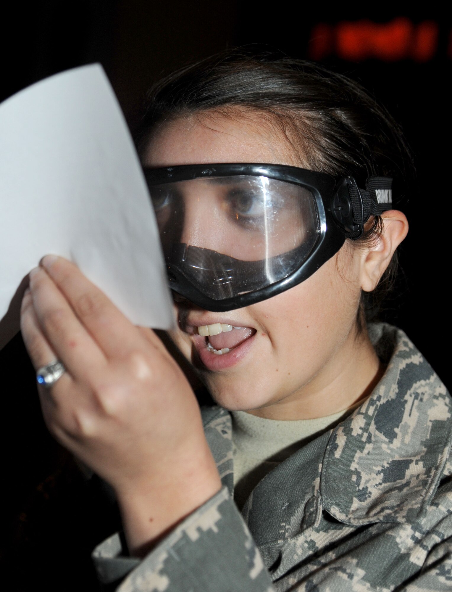 Airman Basic Hannah Calken, 335th Training Squadron, attempts to read a letter while wearing drunk goggles to simulate being intoxicated over the legal limit during a drunk busters program Feb. 14, 2014, at the Welch Theater, Keesler Air Force Base, Miss.  The drunk busters program illustrates the impact and effects of alcohol on a person’s senses and motor skills and is offered to those Airmen getting more responsibility through increase in transition privileges.  (U.S. Air Force photo by Kemberly Groue)