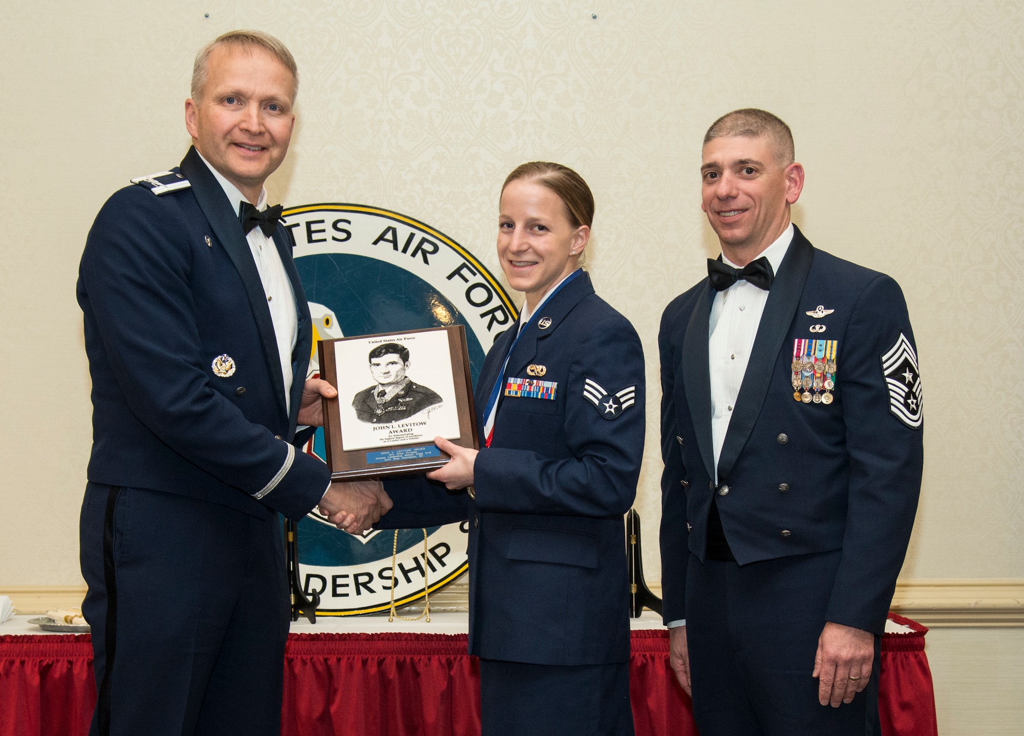 Col. Darren Hartford, 437th Airlift Wing commander, and Chief Master Sgt. Shawn Hughes, 437th AW command chief, present Senior Airman Ellen Gruesen, 437th Maintenance Squadron journeyman, the John Levitow Award during the Airman Leadership School Class 14-B graduation ceremony Feb. 2, 2014, at JB Charleston – Air Base, S.C. The Levitow Award is awarded for a student's exemplary demonstration of excellence, both as a leader and scholar. (U.S. Air Force photo/ Airman 1st Class Clayton Cupit)
