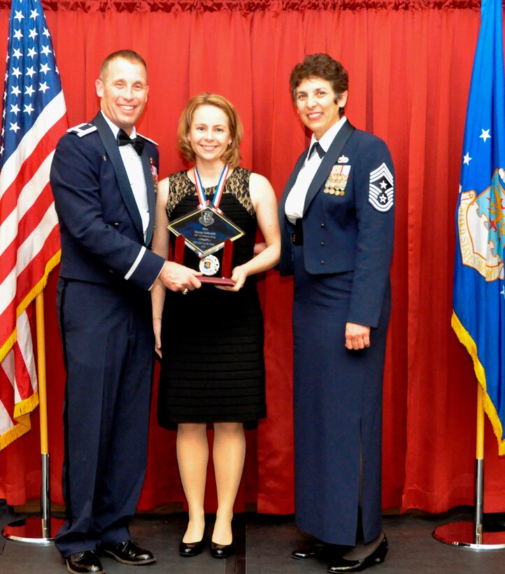 TRAVIS AIR FORCE BASE, Calif. -- Company Grade Officer of the Year, Capt. Lyndsey Ballinger, receives her award from Col. Matt Burger and Command Chief Master Sgt. "Sunny" Santos, at the Feb. 8, 2014, Annual Awards Ball. Assigned to the 749th AMXS, Ballinger is advancing forward in competition to the Fourth Air Force level. (U.S. Air Force photo/Master Sgt. Rachel Martinez)