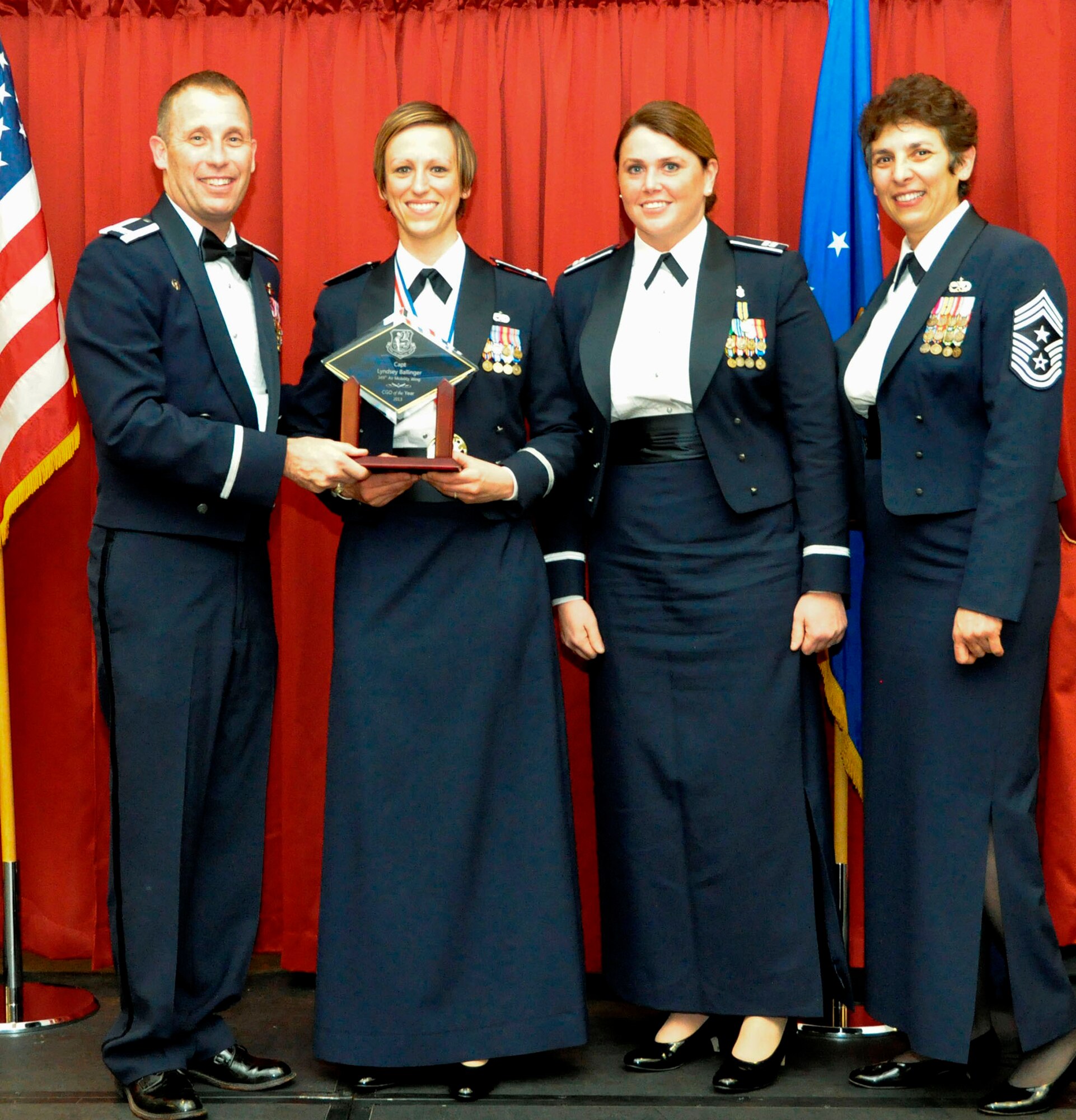 TRAVIS AIR FORCE BASE, Calif. -- Company Grade Officer of the Year, Capt. Lyndsey Ballinger, receives her award from Col. Matt Burger and Command Chief Master Sgt. "Sunny" Santos, at the Feb. 8, 2014, Annual Awards Ball. Assigned to the 749th AMXS, Ballinger is advancing forward in competition to the Fourth Air Force level. (U.S. Air Force photo/Master Sgt. Rachel Martinez)