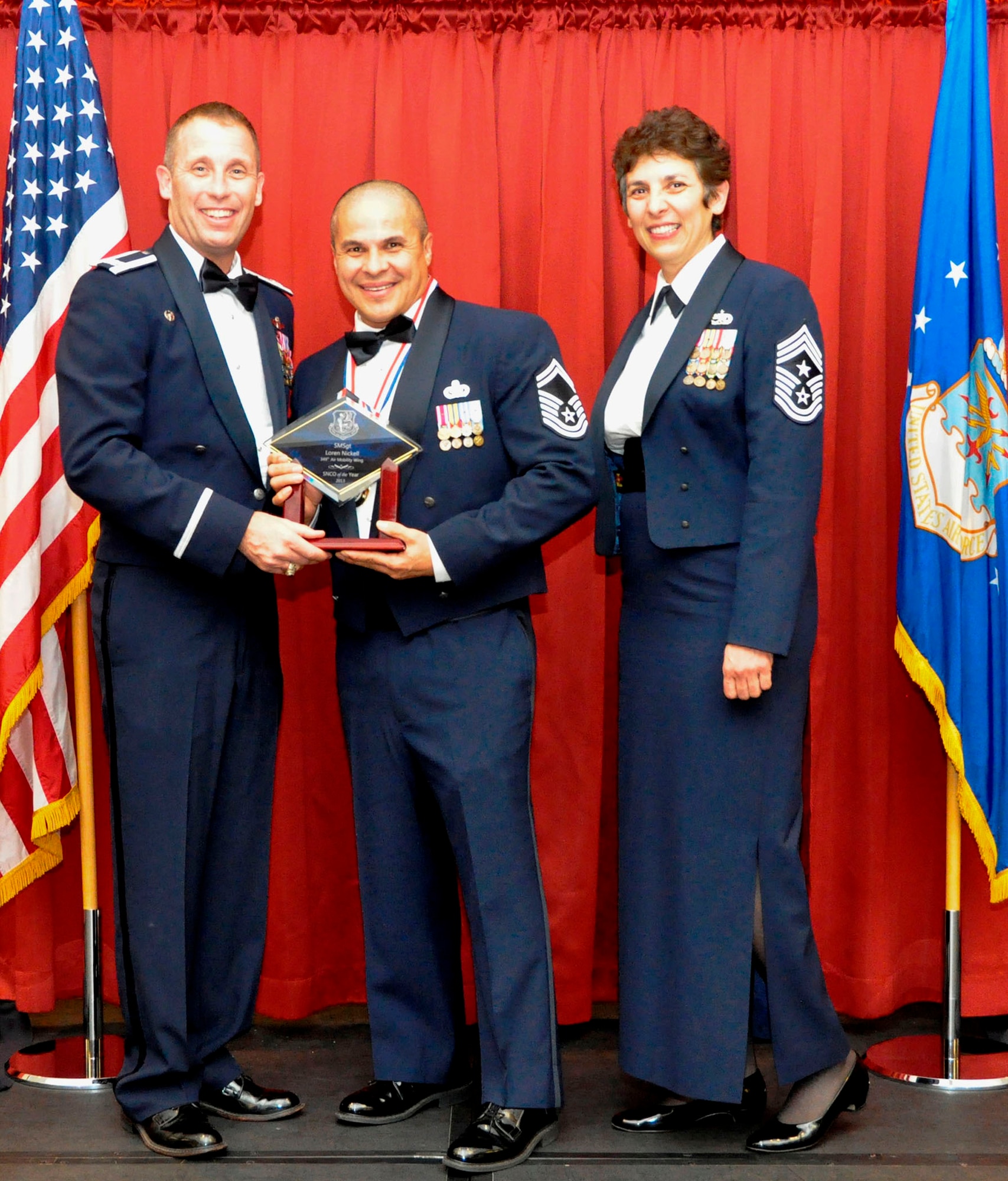 TRAVIS AIR FORCE BASE, Calif. --Senior Master Sgt. Loren Nickell, 2013 Senior Noncommissioned Officer of the Year, is presented his trophy by Col. Matt Burger, wing commander, and CMSgt. "Sunny" Santos, wing command chief. Nickell is an air reserve technician assigned to the 349th LRS. He was selected to advance in the competition to the Fourth Air Force level. (U.S. Air Force photo/Master Sgt. Rachel Martinez)