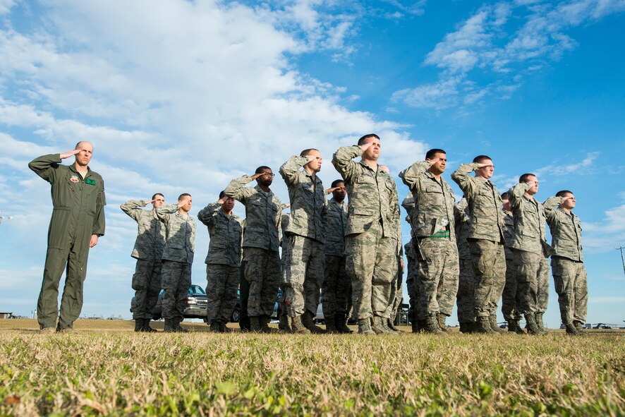 U.S. Air Force Lt. Col. Shawn Cochran, left, 41st Rescue Squadron (RQS) commander, and Airmen from the 41st Helicopter Maintenance Unit and the 41st RQS salute during the playing of Retreat at Moody Air Force Base, Ga., Feb. 14, 2014. The Airmen were gathered for a tree planting ceremony in remembrance of the crew members of the downed helicopter Jolly 22, an HH-60G Pave Hawk which crashed Jan. 7th on the Norfolk coast of England. (U.S. Air Force photo by Airman 1st Class Ryan Callaghan/Released)