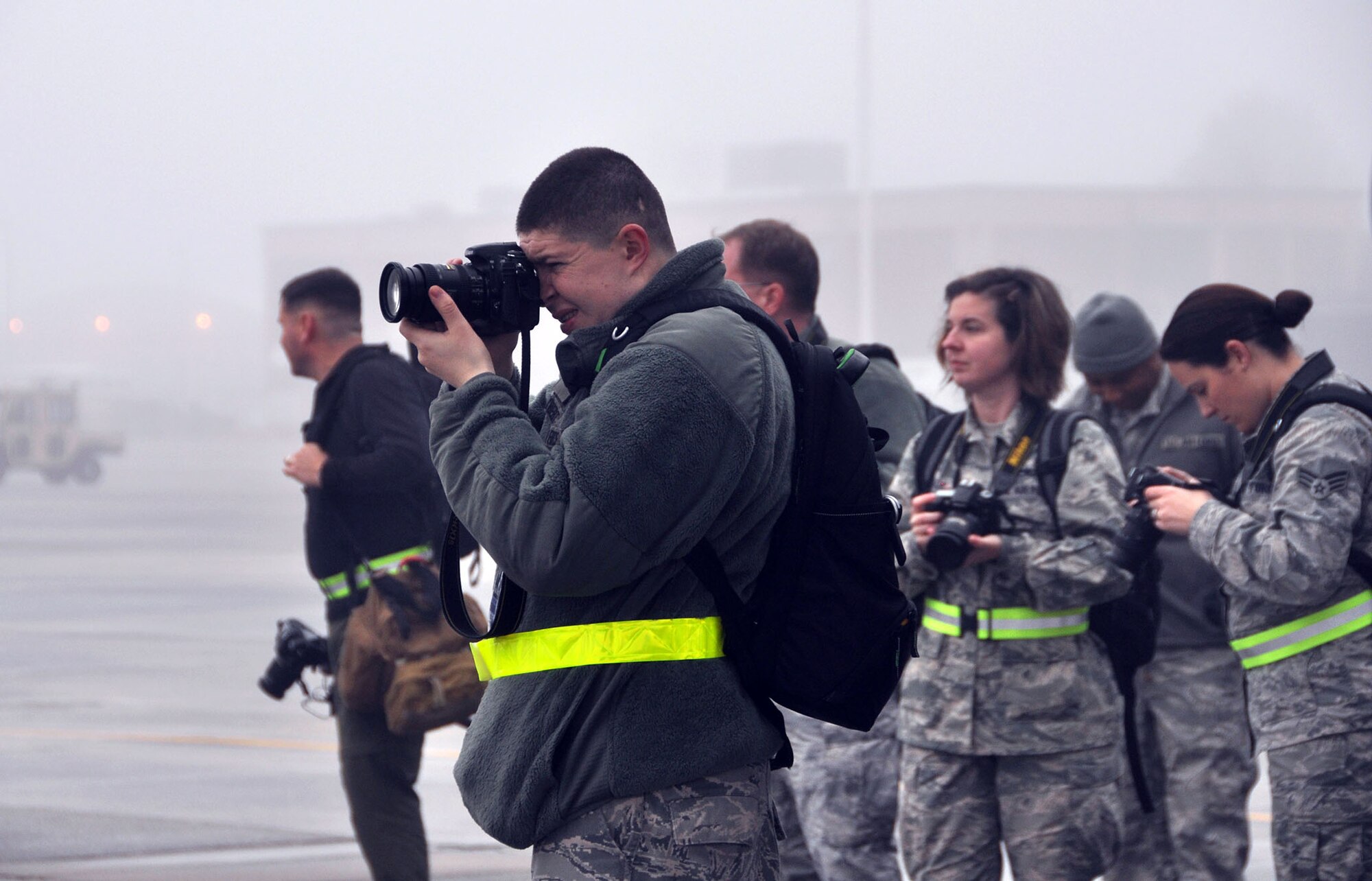 TRAVIS AIR FORCE BASE, Calif. -- Senior Airman Joshua Seybert, a public affairs specialist with the 911th Airlift Wing, and other photojournalists, take part in a foggy, sunrise photography session at Dobbins Air Base, Feb. 2. The two-day course provided reserve and active duty airmen the opportunity to learn from a professional aviation photographer Tony Granata. (U.S. Air Force photo/Senior Airman Cindy Alejandrez)