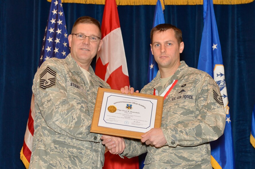 McGHEE TYSON AIR NATIONAL GUARD BASE, Tenn. ? Technical Sgt. Chad W. Rosendale, right, receives the distinguished graduate award for Noncommissioned Officer Academy Class 14-2 from Chief Master Sgt. Thomas K. Stoudt., commandant, Paul H. Lankford Enlisted Professional Military Education Center at the I.G. Brown Training and Education Center here, Feb. 12, 2014 The distinguished graduate award is presented to students in the top ten percent of the class.  It is based on objective and performance evaluations, demonstrated leadership, and performance as a team player. (U.S. Air National Guard photo by Master Sgt. Kurt Skoglund/Released)