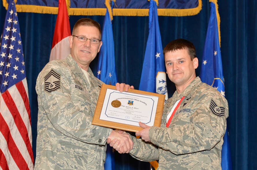 McGHEE TYSON AIR NATIONAL GUARD BASE, Tenn. ? Technical Sgt. James S. Blair, right, receives the distinguished graduate award for Noncommissioned Officer Academy Class 14-2 from Chief Master Sgt. Thomas K. Stoudt., commandant, Paul H. Lankford Enlisted Professional Military Education Center at the I.G. Brown Training and Education Center here, Feb. 12, 2014 The distinguished graduate award is presented to students in the top ten percent of the class.  It is based on objective and performance evaluations, demonstrated leadership, and performance as a team player. (U.S. Air National Guard photo by Master Sgt. Kurt Skoglund/Released)