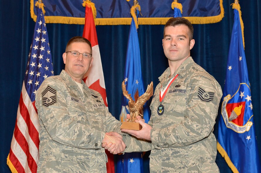 McGHEE TYSON AIR NATIONAL GUARD BASE, Tenn. - Technical Sgt. Brandon Kruger, right, receives the Commandant Award for Noncommissioned Officer Academy Class 14-2 at the I.G. Brown Training and Education Center from Chief Master Sgt. Thomas K. Stoudt, left, commandant of the Paul H. Lankford Enlisted Professional Military Education Center here, Feb. 12, 2014. The award is presented to a student who makes the ?most significant contribution to the overall success of the class by demonstrating superior leadership abilities and excellent skills as a team member.?  It is named in honor of Chief Master Sgt. Paul H. Lankford, a Bataan Death March survivor and the first commandant of the Air National Guard Enlisted Professional Military Education Center. (U.S. Air National Guard photo by Master Sgt. Kurt Skoglund/Released)