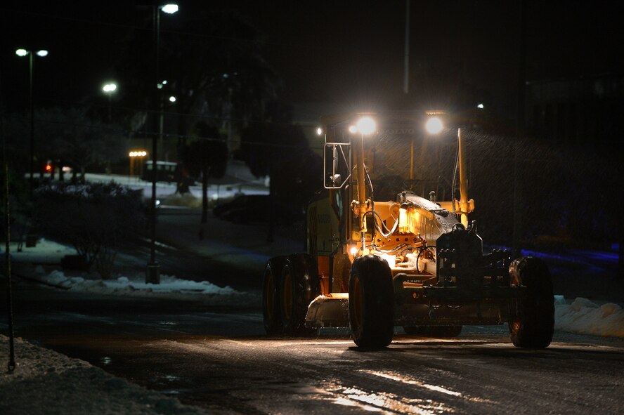 Team Shaw snow removal teams work into the night in order to clear Shaw’s main roads, Feb. 12, 2014, Shaw Air Force Base, S.C. As temperatures continued to drop during the night, thick ice formed over Shaw’s roads and sidewalks. As the inclement weather continues, Team Shaw will continue to operate with "Mission Essential Personnel" only until further advised by the 20th Fighter Wing commander. Team Shaw personnel are urged to stay off the roads and use their best judgment if they do have to go out. (U.S. Air Force photo by Staff Sgt. Kenny Holston/Released)