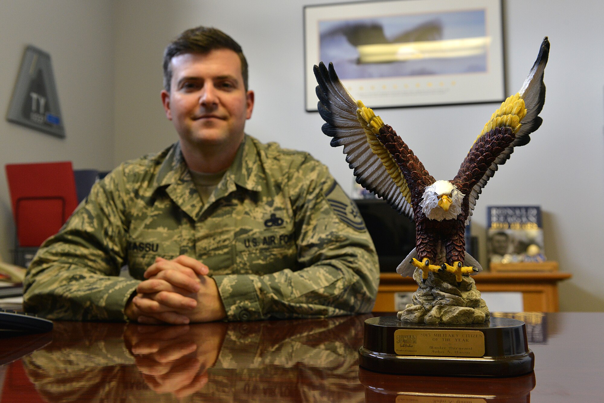 U.S. Air Force Master Sgt. John Yassu, 20th Maintenance Group first sergeant, displays his Military Citizen of the Year award on his desk, Shaw Air Force Base, S.C., Feb. 14, 2014.  The award is given out by the Greater Sumter Chamber of Commerce to a military member who has extensively lent their time to the community, as well as on base involvement through volunteering. (U.S. Air Force photo by Airman 1st Class Jensen Stidham/Released)