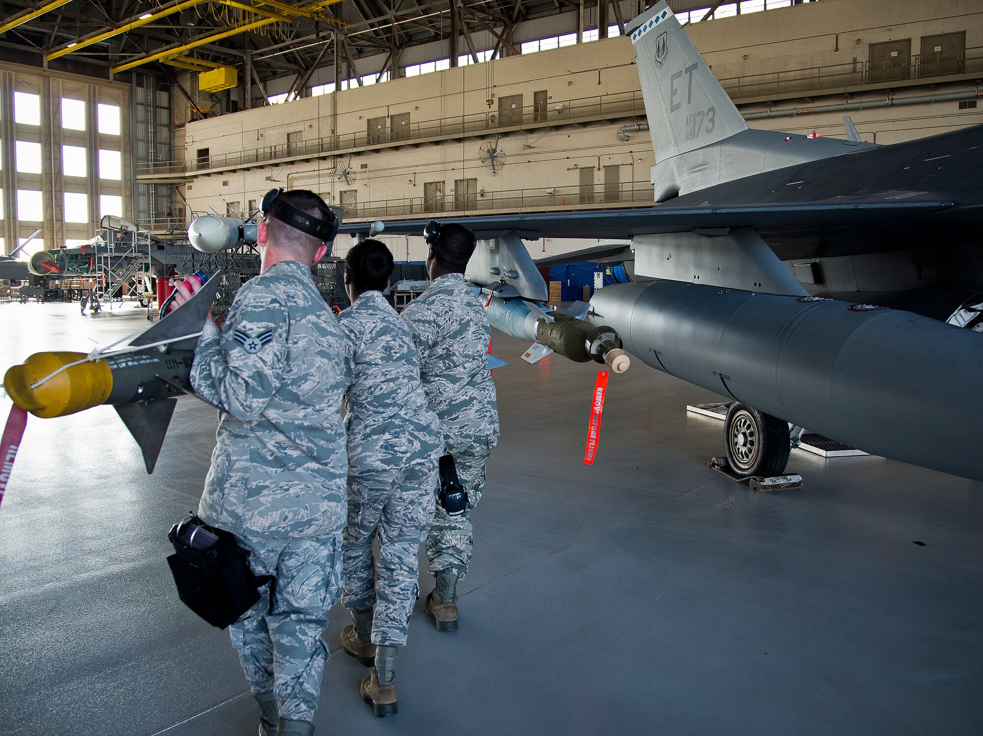 A 96th Aircraft Maintenance Squadron Blue team carries the AIM-9 to their F-16 Fighting Falcon during the first quarter weapons load crew competition Feb. 14 at Eglin Air Force Base, Fla.  Teams from AMU Blue battled AMU Red in loading a GBU, AIM-9 and an AIM-120 on their respective aircraft.  The winners will be announced at the 96th Maintenance Group banquet.  (U.S. Air Force photo/Samuel King Jr.)