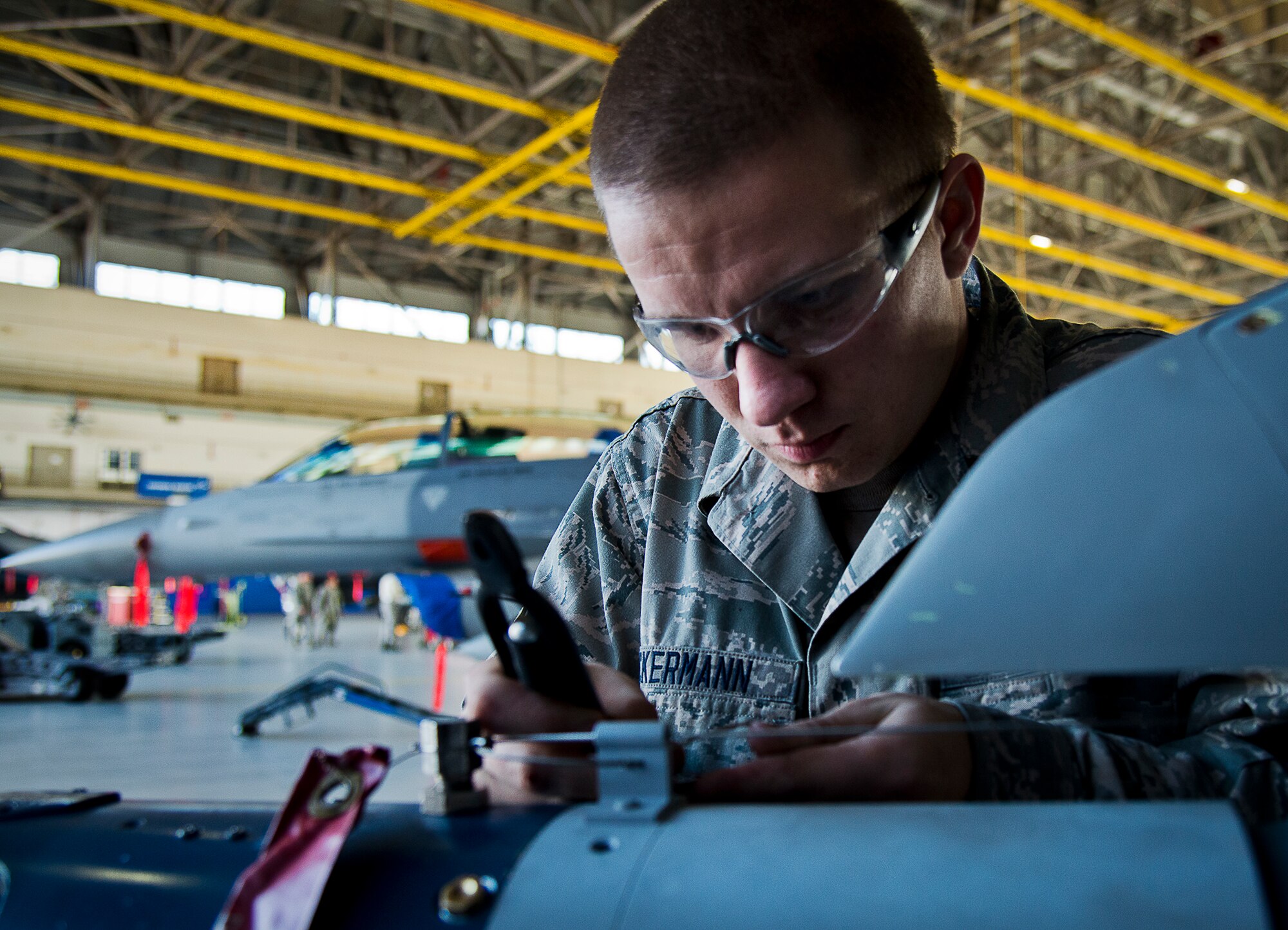 Senior Airman Derron Ackermann, of the 96th Aircraft Maintenance Squadron Blue, completes the complex loading procedures required for the Guided Bomb Unit-12 on his F-16 Fighting Falcon during the annual weapons load crew of the year competition Feb. 14 at Eglin Air Force Base, Fla.  Teams from AMU Blue battled AMU Red in loading a GBU, AIM-9 and an AIM-120 on their respective aircraft.  The winners will be announced at the 96th Maintenance Group banquet.  (U.S. Air Force photo/Samuel King Jr.)
