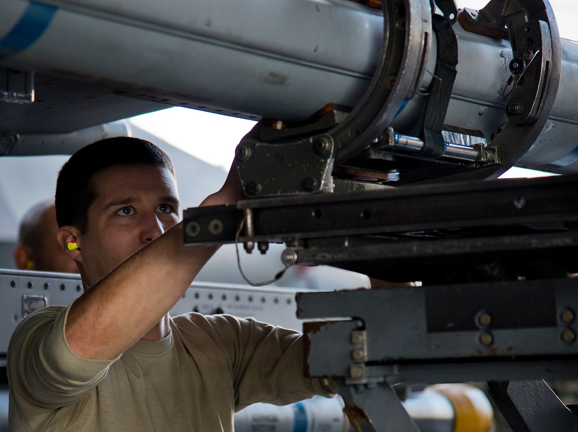 Staff Sgt. Kevin Vinson, of the 96th Aircraft Maintenance Squadron Blue, watches as the the weapons loader lifts the AIM-120 into place on an F-16 Fighting Falcon during the annual weapons load crew of the year competition Feb. 14 at Eglin Air Force Base, Fla.  Teams from AMU Blue battled AMU Red in loading a GBU, AIM-9 and an AIM-120 on their respective aircraft.  The winners will be announced at the 96th Maintenance Group banquet.  (U.S. Air Force photo/Samuel King Jr.)