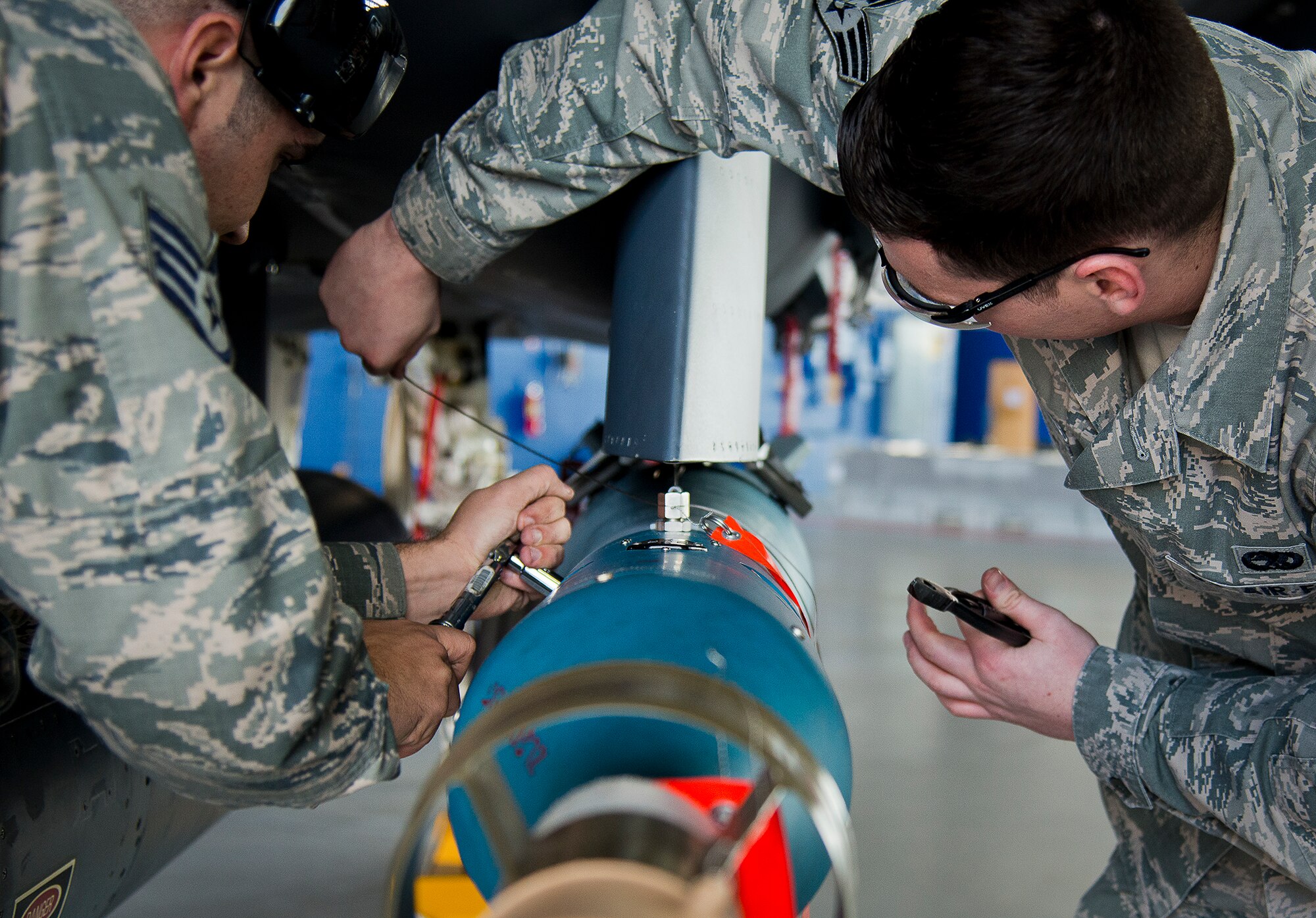 Staff Sgt. Derek Cook and Senior Airman Mark Timpani, of the 96th Aircraft Maintenance Squadron Red, work on the intricate wiring required to complete the Guided Bomb Unit-12 on their F-15 Eagle during the annual weapons load crew of the year competition Feb. 14 at Eglin Air Force Base, Fla.  Teams from AMU Blue battled AMU Red in loading a GBU, AIM-9 and an AIM-120 on their respective aircraft.  The winners will be announced at the 96th Maintenance Group banquet.  (U.S. Air Force photo/Samuel King Jr.)