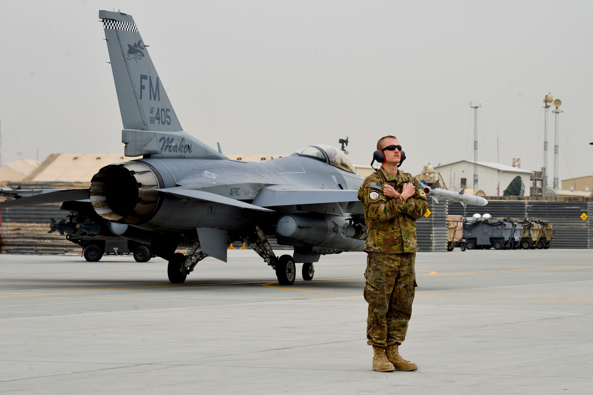 U.S. Air Force Senior Airman Jeremy Guay, 455th Expeditionary Aircraft Maintenance Squadron crew chief, prepares to marshal an F-16 Fighting Falcon at Bagram Airfield, Afghanistan, Feb. 18, 2014. Guay is deployed from Homestead Air Reserve Base, Fla., and a native of Washington state.  (U.S. Air Force photo by Senior Airman Kayla Newman/Released)