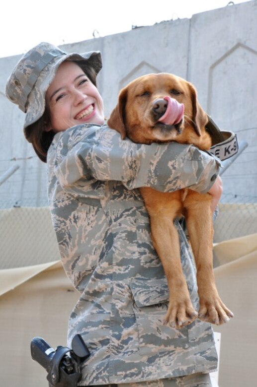 Air Force Senior Airman Samantha Baker, a military working dog handler deployed to the 380th Expeditionary Security Forces Squadron, gives her partner, Penny, a hug after successfully completing a training session. Baker is originally from Derby, Kan. (U.S. Air Force photo by Master Sgt. April Lapetoda/Released)