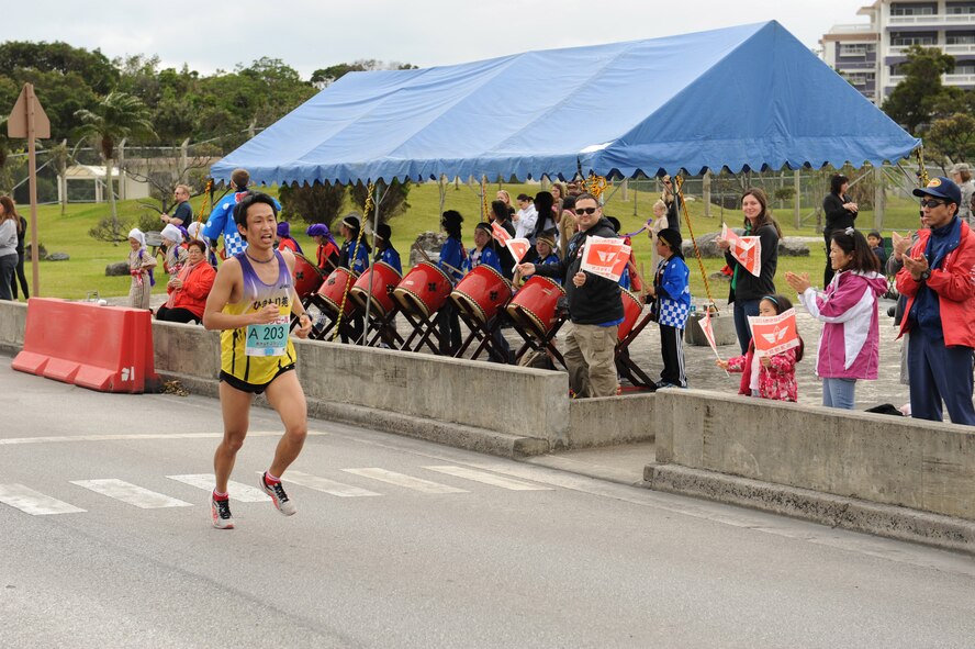 A runner enters Kadena's Gate 2 during the 2014 Okinawa Marathon on Kadena Air Base, Japan, Feb. 16, 2014. For 22 years, Kadena has supported the Okinawa Marathon by providing volunteers and opening the base for the 2.8 km route for the runners to run. (U.S. Air Force photo by Airman 1st Class Keith James)