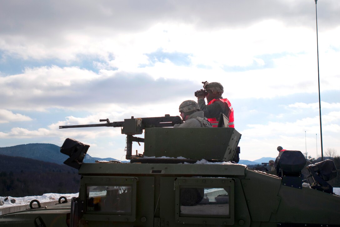 Army Spc. Fredrick Burney, left, qualifies with a .50-caliber M2 machine gun with help from his spotter, Army Sgt. Christopher Wheatley, on Camp Ethan Allen Training Site in Jericho, Vt., Feb. 8, 2014. Burney and Wheatley are assigned to Vermont National Guard's Headquarters Company, 86th Brigade Special Troops Battalion, Detachment 1 Military Police.