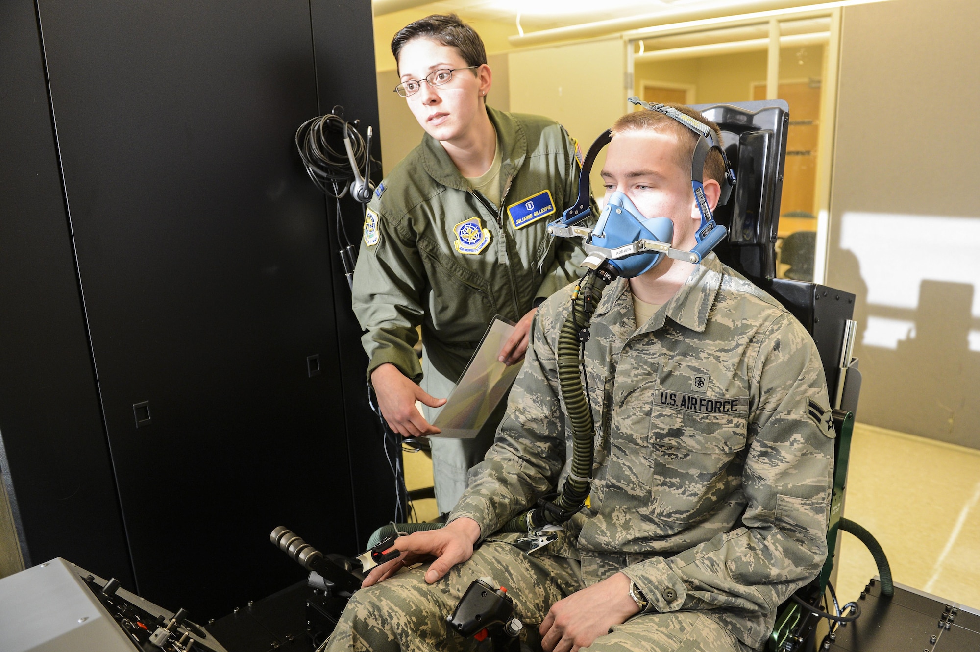 Capt. Julianne Gillespie checks the breathing of Airman 1st Class Erich Held doubling as a pilot using the Reduced Oxygen Breathing Device at the McChord Field clinic Feb. 5, 2014, at Joint Base Lewis-McChord, Wash. The ROBD will ultimately replace the more expensive altitude chamber for the required re-fresher training aircrew needs every five years. Gillespie is a 62nd Airlift Wing aerospace and operational physiologist and Held is a 62nd Medical Squadron optometry technician. (U.S. Air Force photo/Tech. Sgt. Sean Tobin)
 