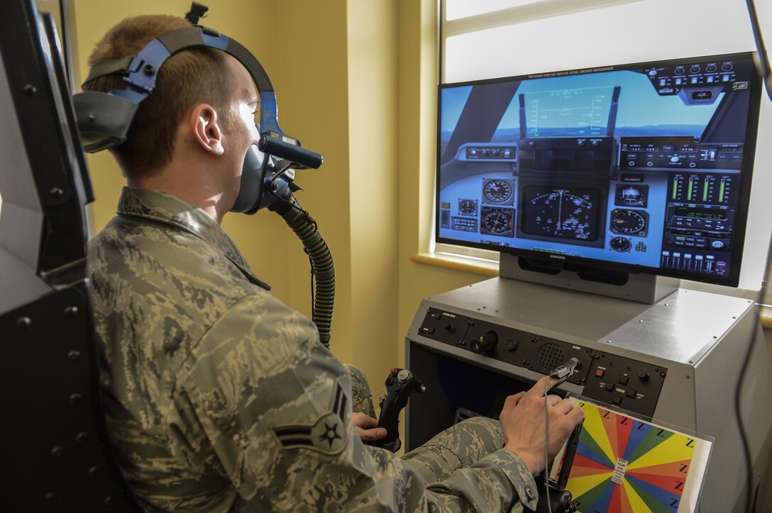 Airman 1st Class Erich Held demonstrates how pilots would use the Reduced Oxygen Breathing Device at the McChord Clinic, Feb. 5, 2014, Joint Base Lewis-McChord, Wash. The ROBD is combined with a flight simulator that can change its heads up display to match the specific aircraft the training pilot flies. Held is a 62nd Medical Squadron optometry technician. (U.S. Air Force photo/Tech. Sgt. Sean Tobin)
 