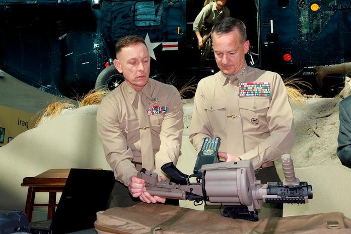 Brig. Gen. Frank Kelley (left), commander of Marine Corps Systems Command, steadies an M32A1 multi-shot grenade launcher as Lt. Gen. William Faulkner, deputy commandant for Installations and Logistics, scans a newly affixed item unique identification marking. A ceremony Feb. 18 at the National Museum of the Marine Corps in Triangle, Va., showcased the 1 millionth IUID placed on an item for the Marine Corps. 