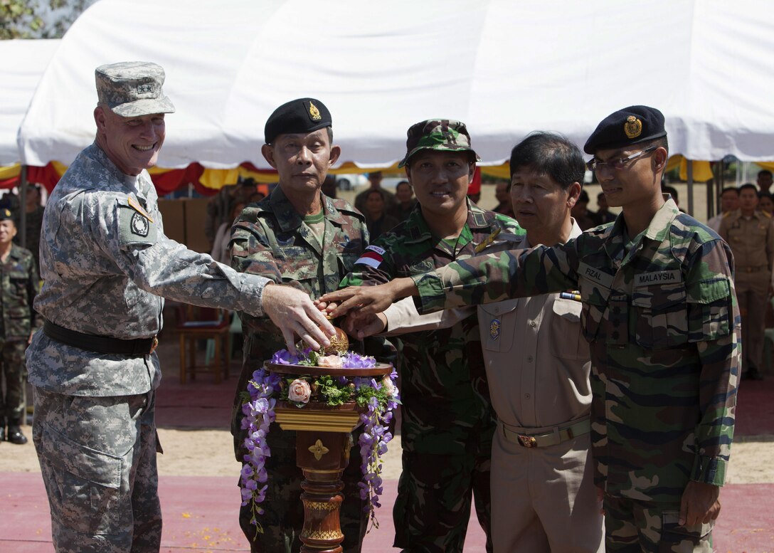 Mutlinational service members push a button revealing a placard during a dedication ceremony Feb. 19 at the Ban Sa la Kai Fub School as part of Exercise Cobra Gold 2014 in Sukhothai, Kingdom of Thailand. During the exercise, four schools were constructed throughout Thailand. CG 14, in its 33rd iteration, demonstrates the U.S. and the Kingdom of Thailand's commitment to their long-standing alliance and regional partnership, prosperity and security in the Asia-Pacific region. 