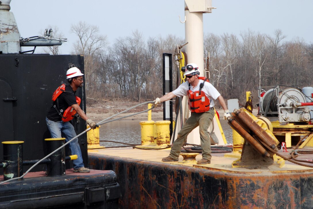 Ensley Engineer Yard and Marine Maintenance Center's Plant Section in operation. Deckhand Marcus Grant passes tie off cable to Brandon Carmack as Motor Vesel Lusk faces up against the Revetment Mooring Barge 7401. (USACE Photo/Brenda Beasley)