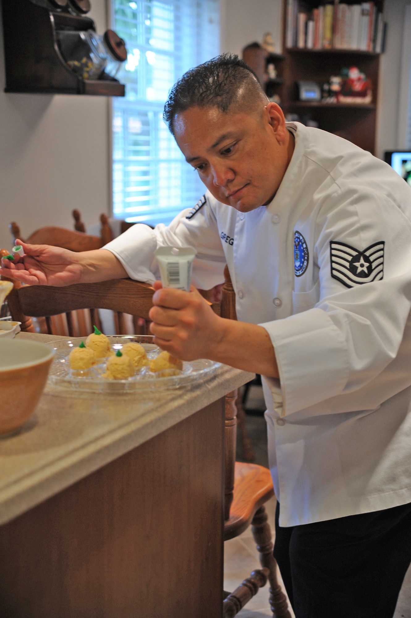 Master Sergeant Jessie Gregorio puts the finishing touches on food to be served at a party. (Photo by Sarah Corrice)