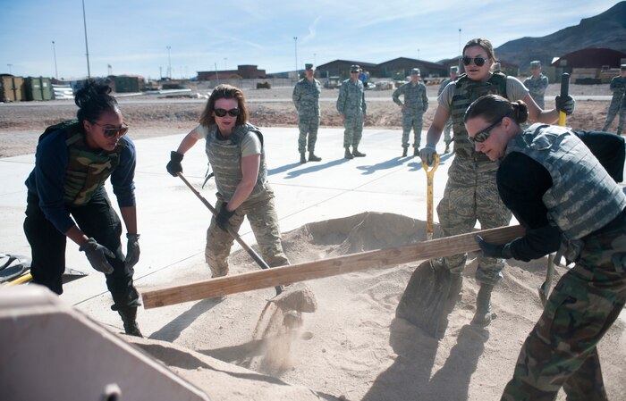 The 99th Force Support Squadron “Grilled Cheese and IDs” team shovel sand into a loader during the 820th RED HORSE Life of a Warrior challenge in Area 2 Feb. 13, 2014, at Nellis Air Force Base, Nev. As part of the challenge, the teams had to fill the loader completely. The 99th FSS "Grilled Cheese and IDs" team was the only all-female team to participate in the challenge. Life of a Warrior is designed for people to strive to achieve his or her maximum potential. (U.S. Air Force photo by Airman 1st Class Jake Carter)

