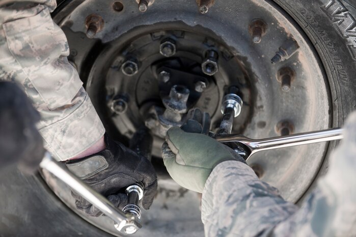 Airmen remove a wheel from a Humvee during the 820th RED HORSE Life of a Warrior challenge in Area 2 Feb. 13, 2014, at Nellis Air Force Base, Nev. Twenty-one teams were timed while removing a wheel and rolling it around the Humvee and putting it back on. The team that finished in first place was “4 Horsemen” from 820th RED HORSE with a time of 16 minutes, 35 seconds. Life of a Warrior is designed for people to strive to achieve his or her maximum potential.  (U.S. Air Force photo by Airman 1st Class Jake Carter)