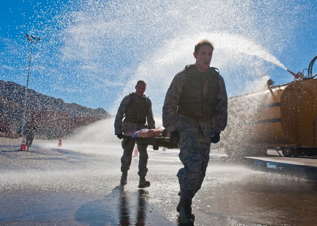The 820th RED HORSE "LG" team carry a litter with a 145 pound dummy while getting sprayed with water during the 820th RED HORSE Life of a Warrior challenge in Area 2 Feb. 13, 2014, at Nellis Air Force Base, Nev. The course consisted of six stations that tested teams mentally and physically. Life of a Warrior is designed for people to strive to achieve his or her maximum potential.  (U.S. Air Force photo by Senior Airman Christopher Tam)