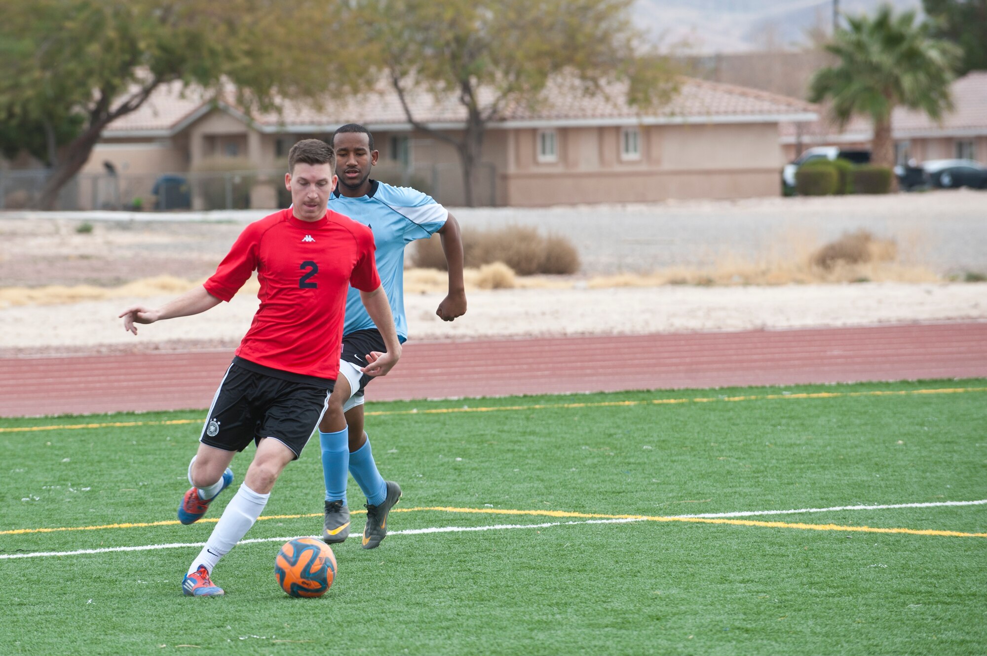 Thomas Fitton, number two and Nellis Air Force Base soccer team forward, gets past an Edwards AFB defender Feb. 15, 2014, at the soccer field behind the Warrior Fitness Center at Nellis AFB, Nev. Nellis AFB held the 2014 Nellis Cup Military Soccer Tournament here from Feb. 15 - Feb. 17, 2014 as Nellis AFB team one won the tournament winning all four games. (U.S. Air Force photo by Airman 1st Class Jake Carter)