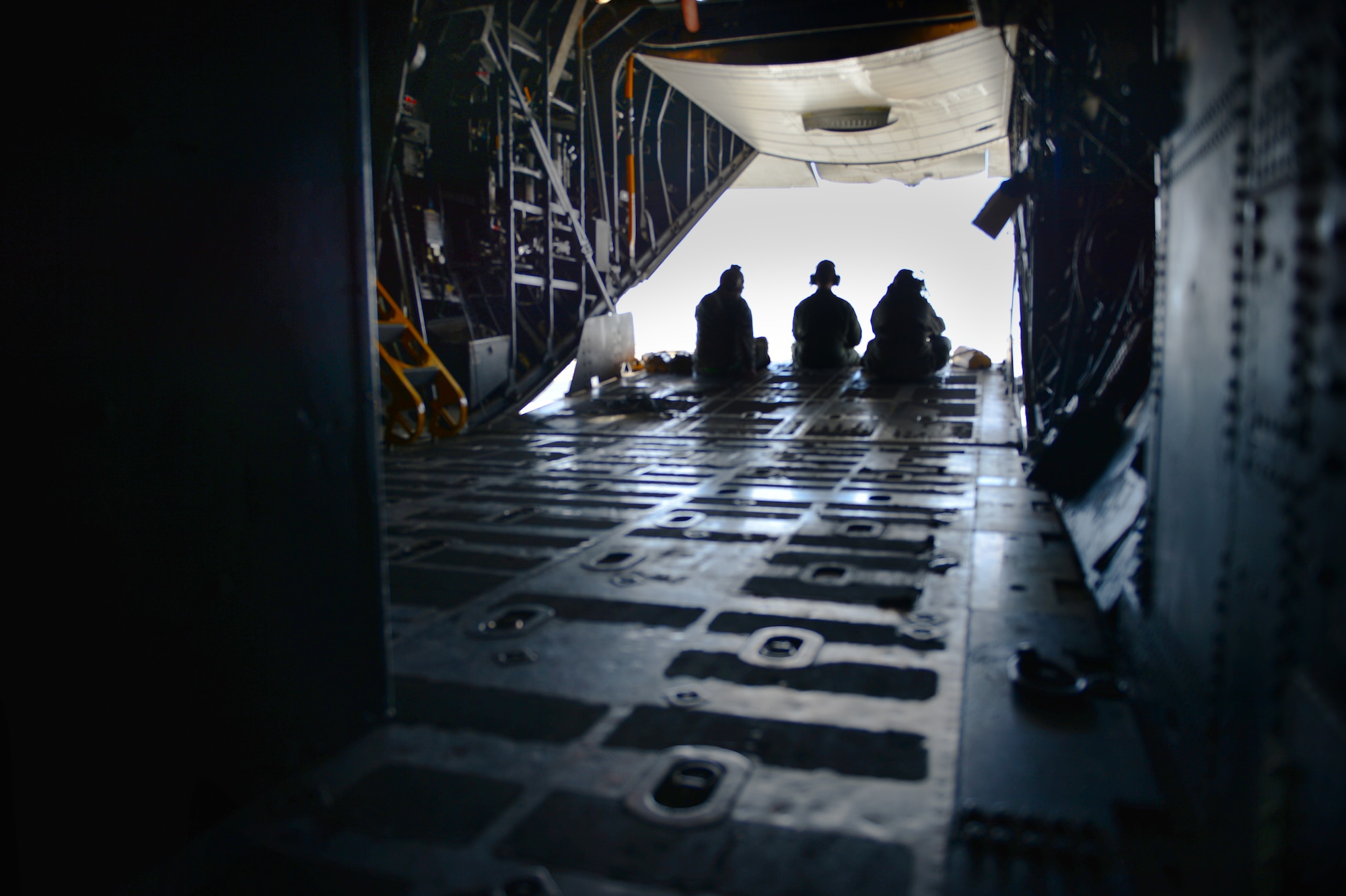 U.S. Air Force Master Sgt. Stephen White, 27th Special Operations Aircraft Maintenance Squadron lead production superintendent, Senior Airman Kyle Olmsted, 16th Special Operations Squadron loadmaster, and Senior Airman Katherine Bontuyan, 27 SOAMXS dedicated crew chief for "Bad Company" peer out of the back of the AC-130H Spectre gunship Bad Company as it taxis on the runway after landing at Davis-Monthan Air Force Base, Ariz., Feb. 7, 2014. Built in 1969 Bad Company is the first of six Spectre gunships scheduled to make the trip to Davis-Monthan Air Force Base, Ariz. (U.S. Air Force photo/ Senior Airman Eboni Reece)