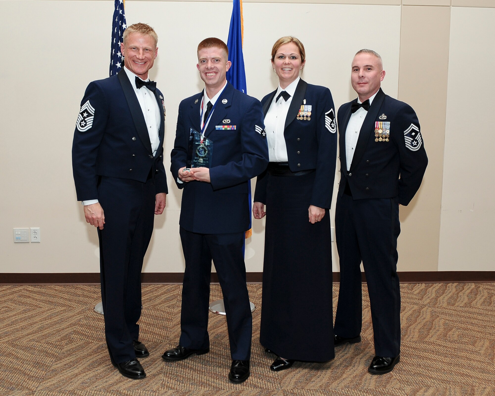 Senior Airman Jonathan Compton, 460th Civil Engineer Squadron, center left, receives the Leadership Award during the Buckley Airman Leadership School Class 14-B graduation Feb. 13, 2014, at the Leadership Development Center on Buckley Air Force Base, Colo. This award is presented to the graduate who displays the best overall characteristics of an effective leader. (U.S. Air Force photo by Senior Airman Phillip Houk/Released)